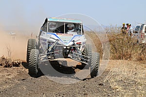 Front view close-up of white Chenowth rally car going down slope